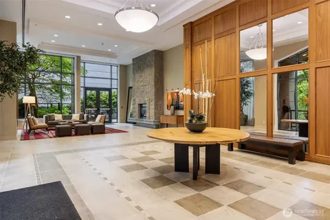 a living room with furniture a large window and a potted plant