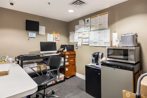 a view of a workspace with furniture and a window