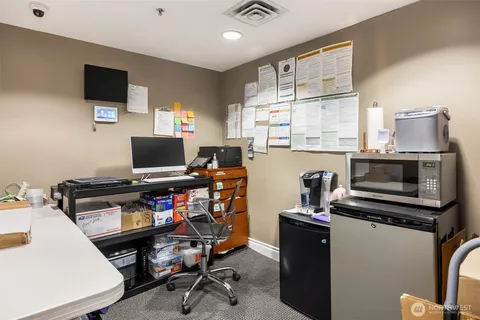 a view of a workspace with furniture and a window