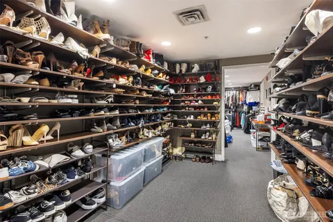 a view of walk in closet with clothes and shoes