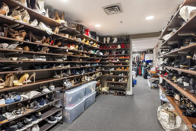 a view of walk in closet with clothes and shoes