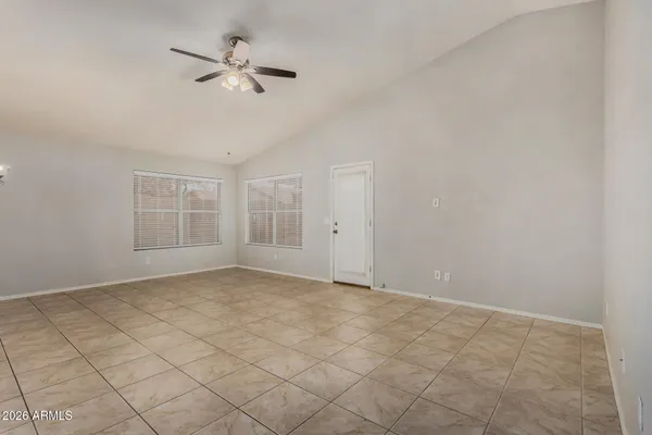 a view of an empty room with a chandelier fan