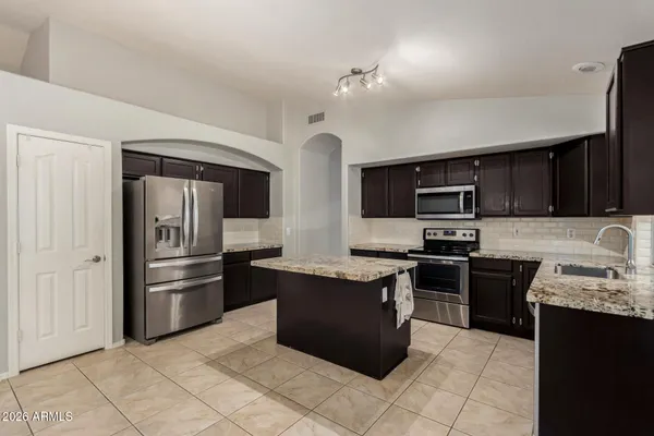 a view of a kitchen with a sink stainless steel appliances and cabinets