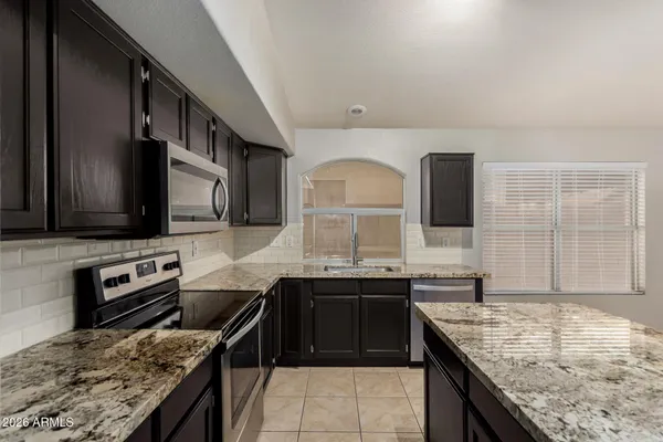 a large kitchen with stainless steel appliances and a sink