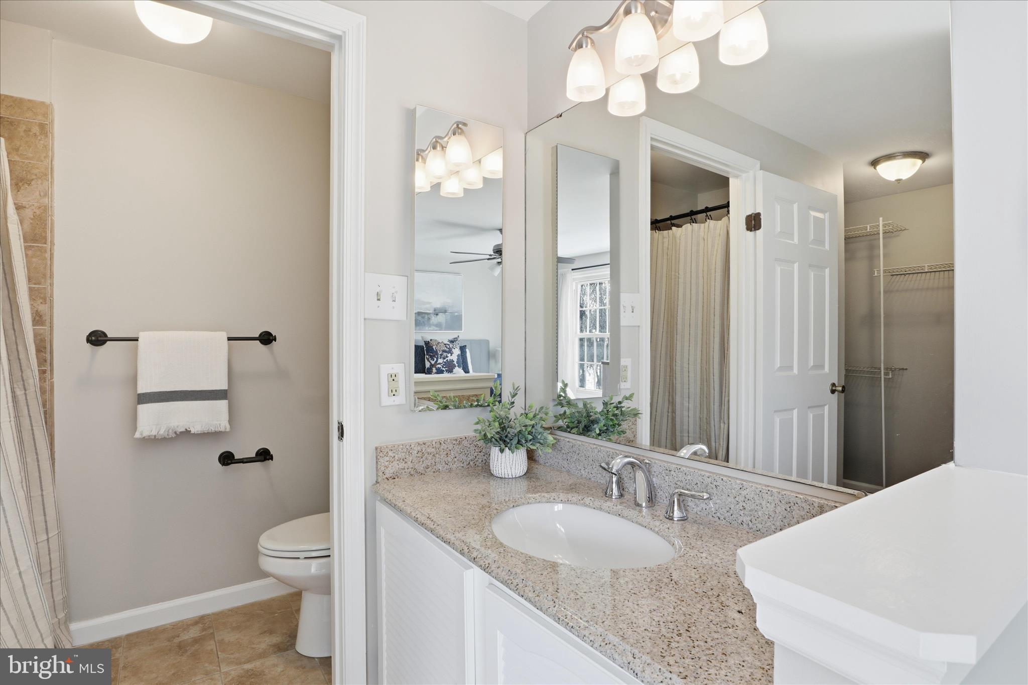 1563 Twisted Oak Drive Reston, VA 20194 - Photo 23 of 47 a spacious bathroom with a granite countertop sink a toilet and a mirror