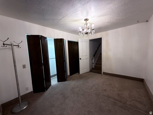2855 South 1000 West Perry, UT 84302 - Photo 112 of 142 Unfurnished dining area with a textured ceiling, dark carpet, and suspended lighting