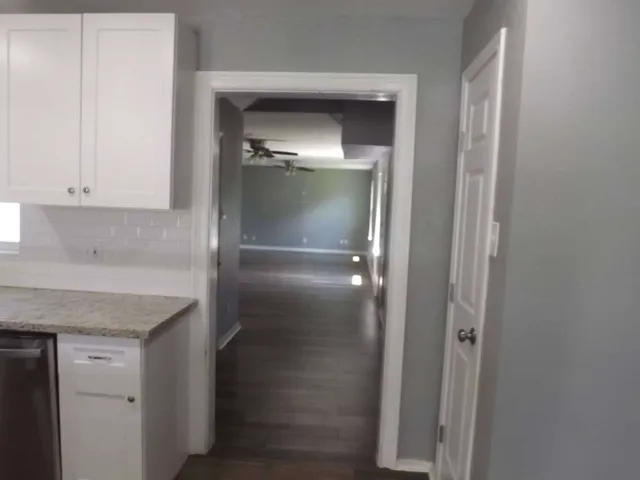a bathroom with a granite countertop sink and cabinets
