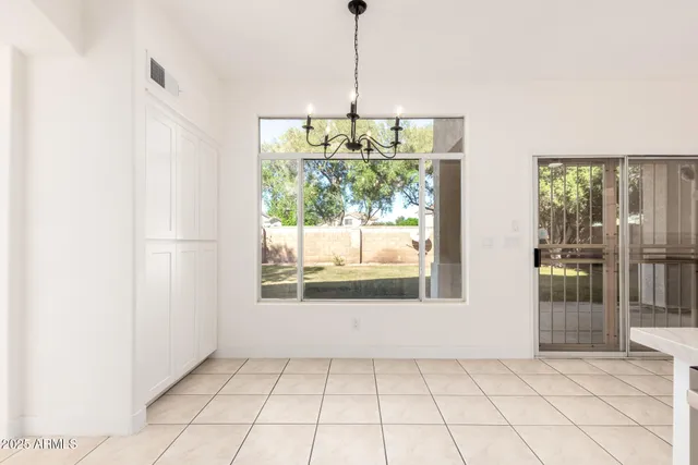 a kitchen with white cabinets and window