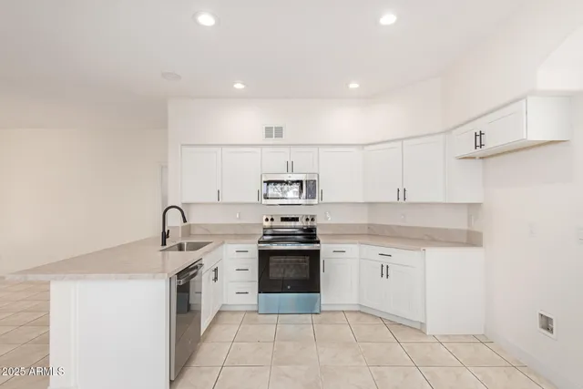 a kitchen with a stove sink and cabinets