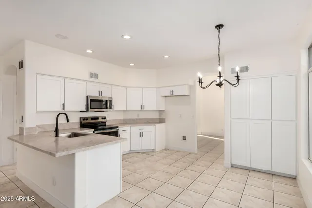 a kitchen with kitchen island a sink appliances and cabinets