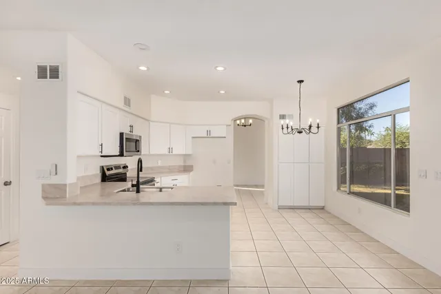 a kitchen with stainless steel appliances kitchen island granite countertop a refrigerator a stove and a sink