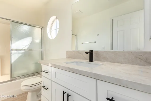 a bathroom with a sink a toilet and a mirror