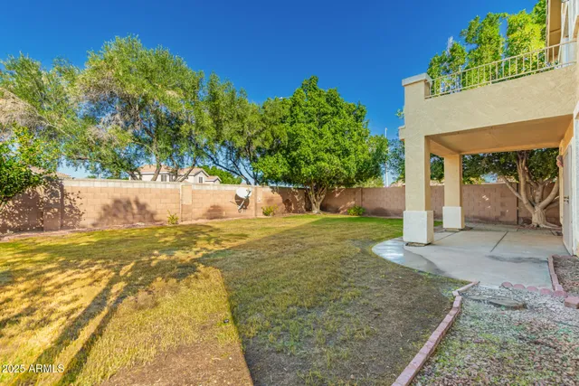 a view of a white house with many windows and plants