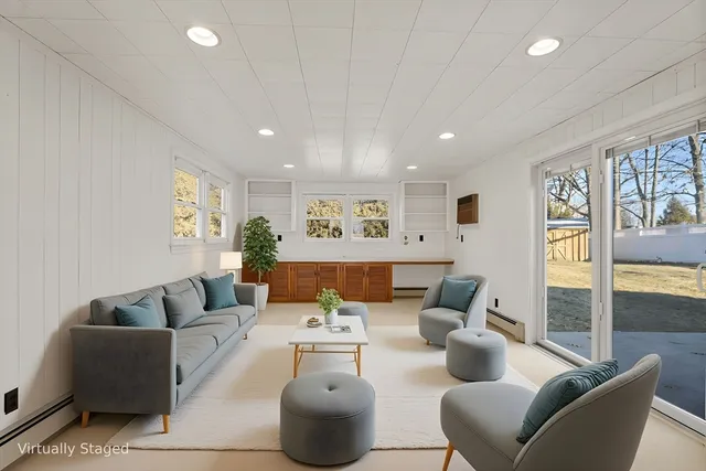 a living room with furniture and a painting on the wall