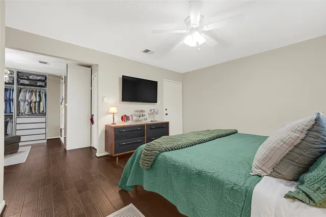 a spacious bedroom with a bed and a chandelier