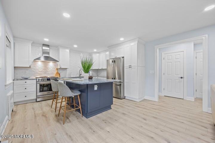283 Spring Street, Unit 3A Red Bank, NJ 07701 - Photo 3 of 20 a kitchen with stainless steel appliances kitchen island hardwood floor sink and stove