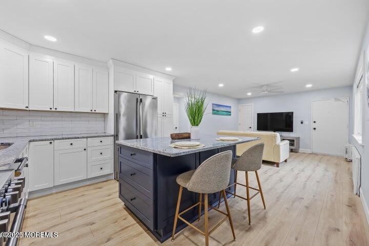 283 Spring Street, Unit 3A Red Bank, NJ 07701 - Photo 4 of 20 a kitchen with stainless steel appliances a table and chairs in it