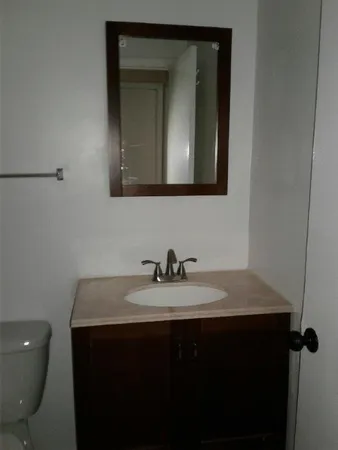 a bathroom with a sink a toilet and mirror