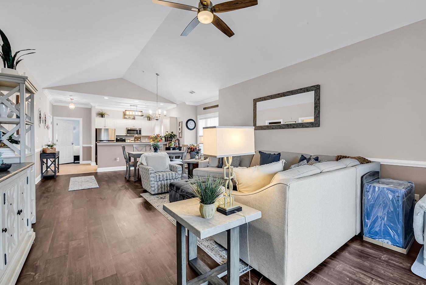124 South Shore Boulevard, Unit 301 Longs, SC 29568 - Photo 4 of 27 Living room with dark wood finished floors, a ceiling fan, vaulted ceiling, a chandelier, and ornamental molding