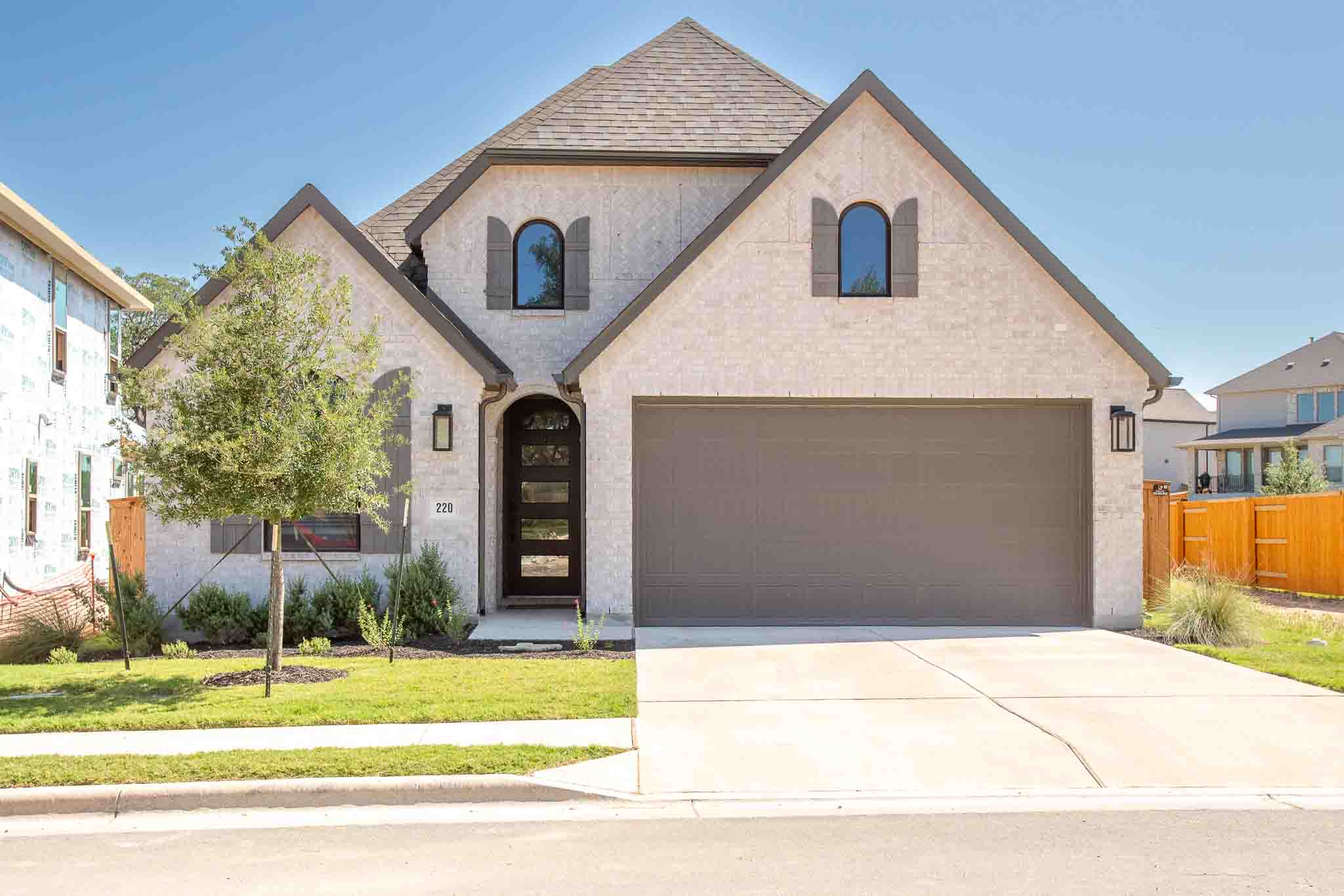 A striking facade with light brick and arched windows creates inviting curb appeal.