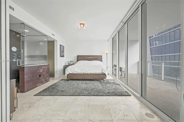 a bedroom with a bed and glass door