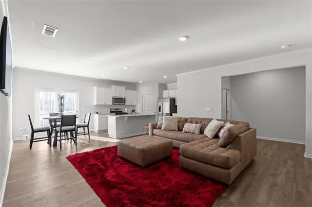 a living room with furniture kitchen view and a dining table