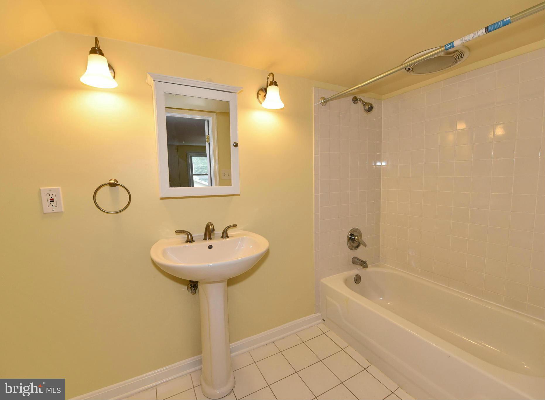 2138 Spencerville Road Spencerville, MD 20868 - Photo 19 of 30 a bathroom with a sink a mirror and a bathtub
