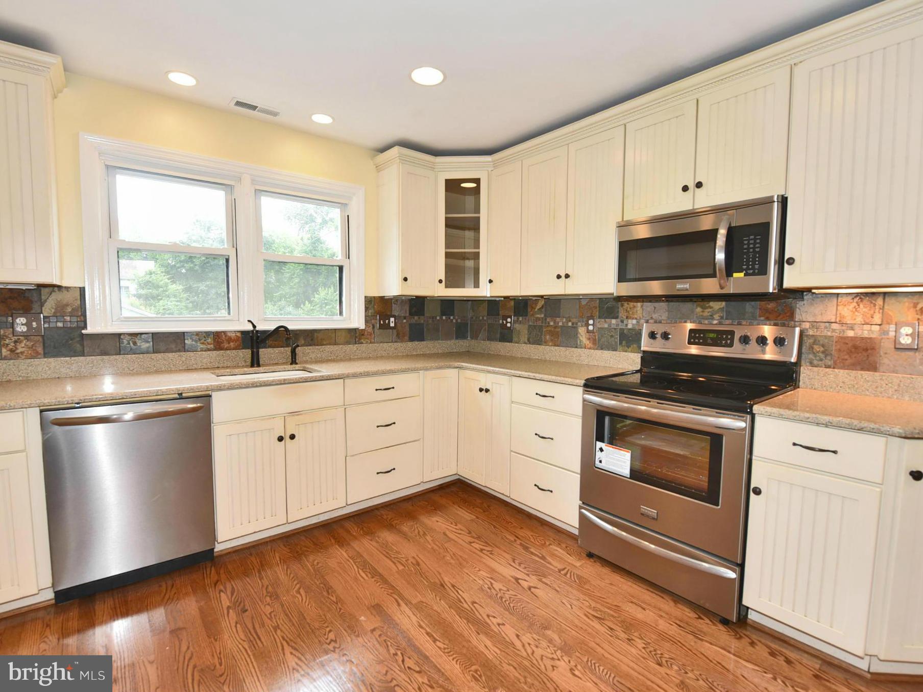 2138 Spencerville Road Spencerville, MD 20868 - Photo 8 of 30 a kitchen with stainless steel appliances granite countertop a stove a sink and white cabinets
