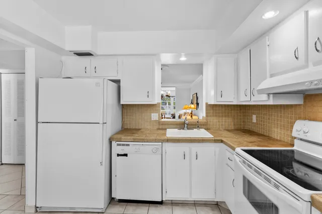 a kitchen with white cabinets and white appliances