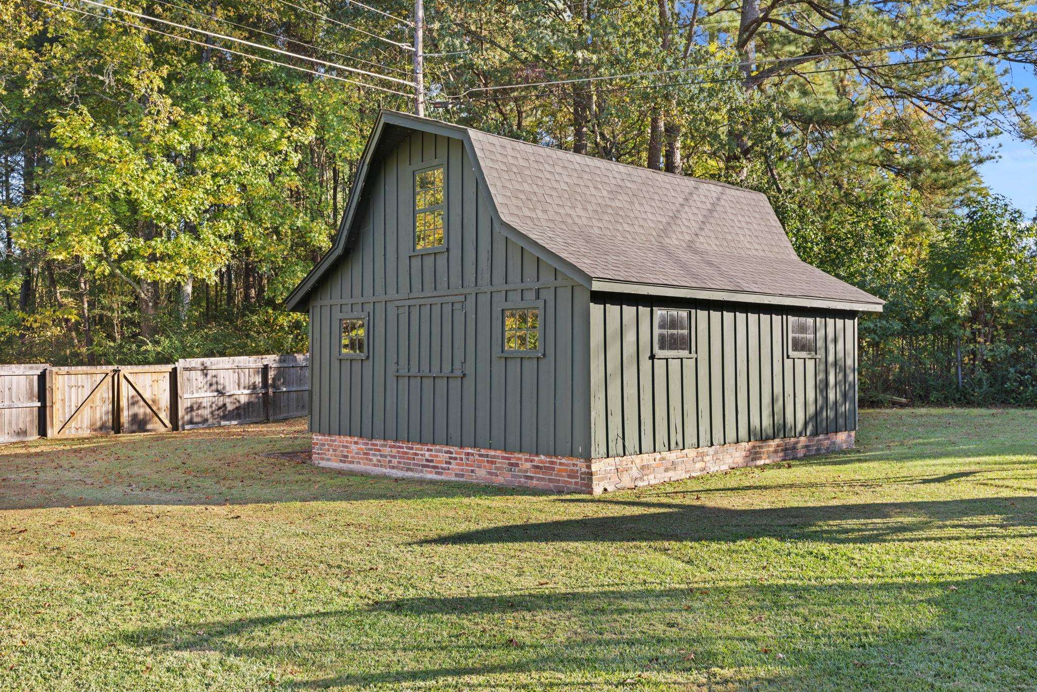 1201 West Clover Lane Corinth, MS 38834 - Photo 11 of 35 View of outbuilding featuring view of wooded area, a fenced backyard, and a gate