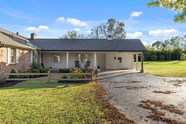 a view of a house with yard and sitting area