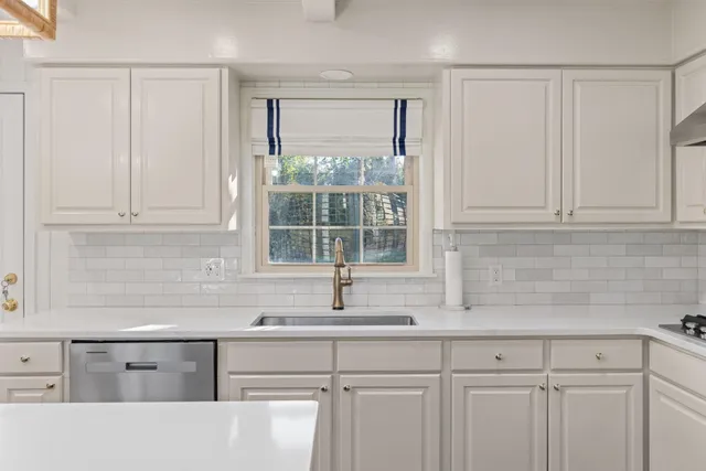 a kitchen with granite countertop white cabinets and sink