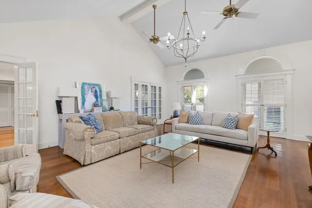 a living room with furniture chandelier and a table