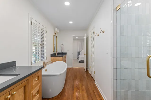 a bathroom with a sink a toilet a shower and a window