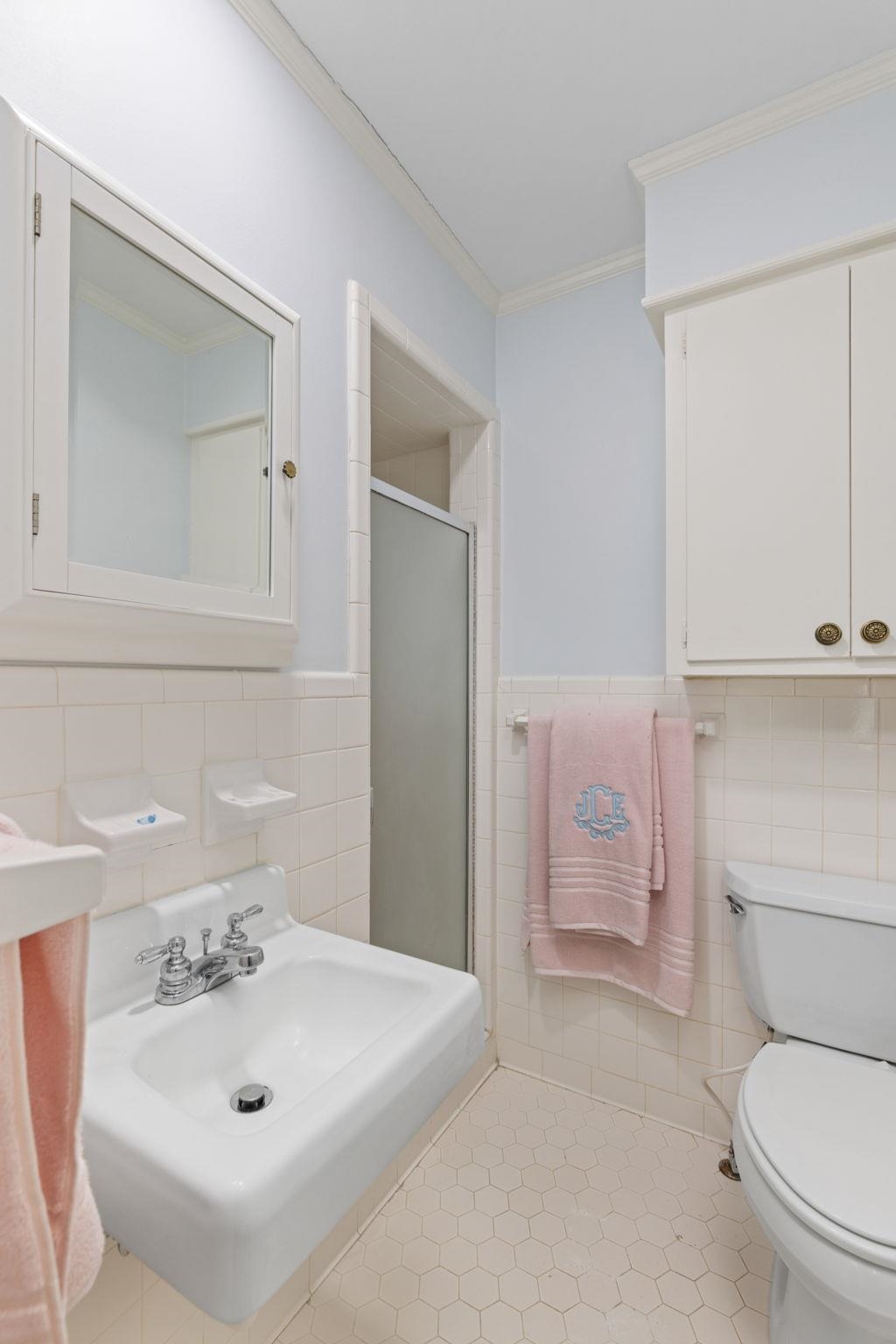 1201 West Clover Lane Corinth, MS 38834 - Photo 29 of 35 Bathroom with a shower stall, ornamental molding, tile walls, light tile patterned flooring, and wainscoting
