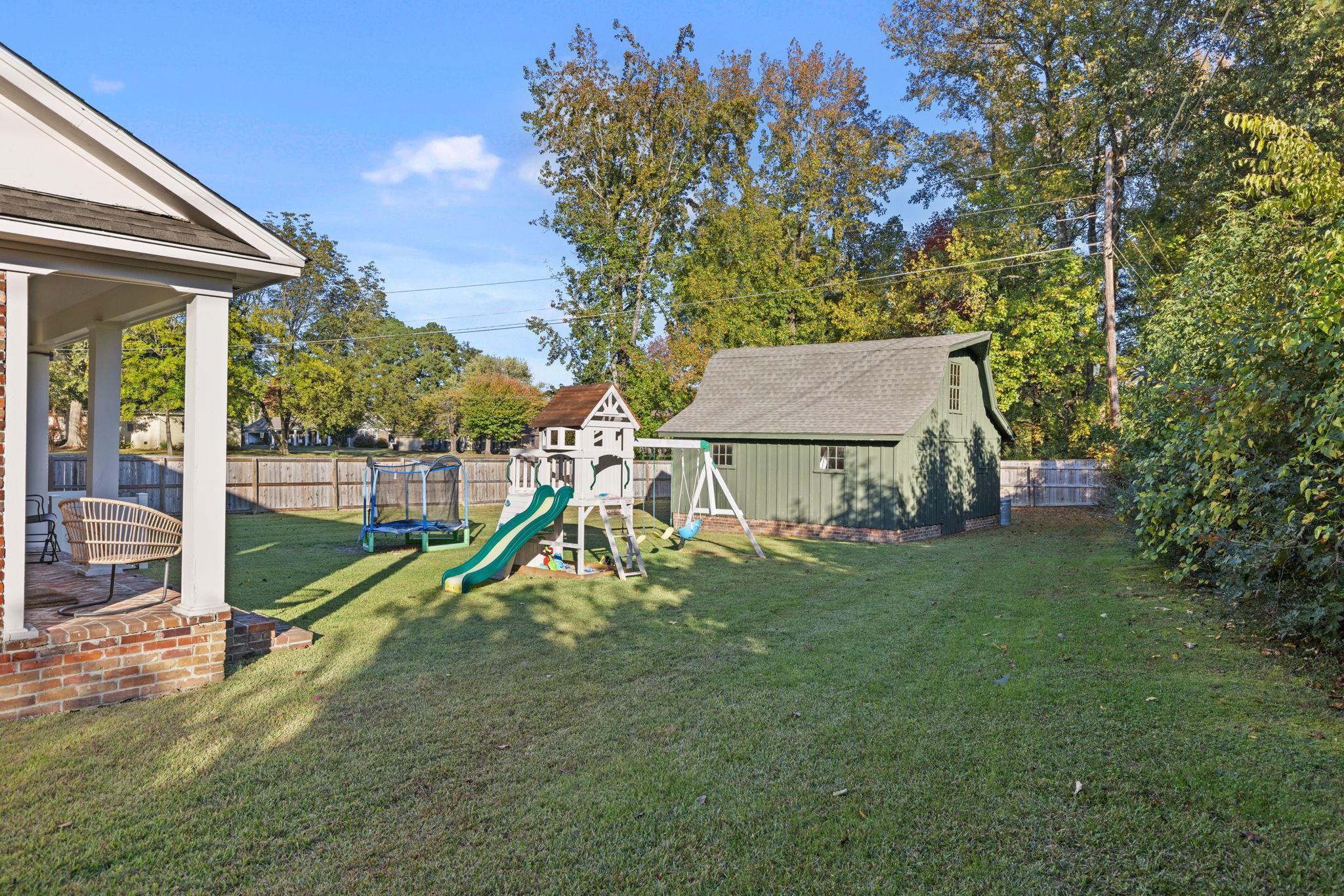 1201 West Clover Lane Corinth, MS 38834 - Photo 35 of 35 Fenced backyard featuring a trampoline, a patio area, a playground, and an outbuilding