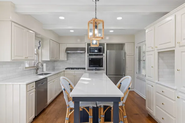 a kitchen with a table chairs refrigerator and microwave