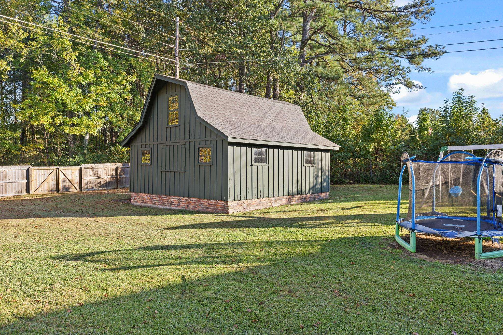 1201 West Clover Lane Corinth, MS 38834 - Photo 10 of 35 View of outbuilding with a trampoline, view of wooded area, and a gate