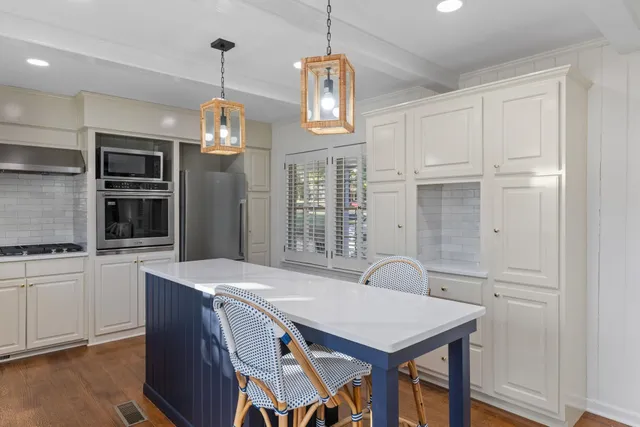 a view of a kitchen area with furniture and stainless steel appliances