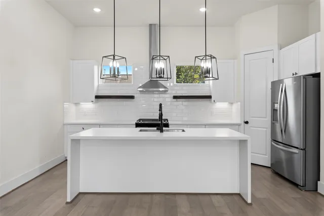 a kitchen with kitchen island a counter top space cabinets and stainless steel appliances