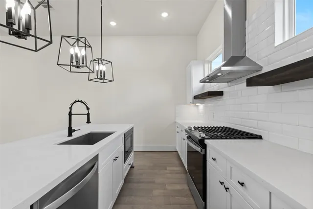 a kitchen with stainless steel appliances a sink a stove and cabinets