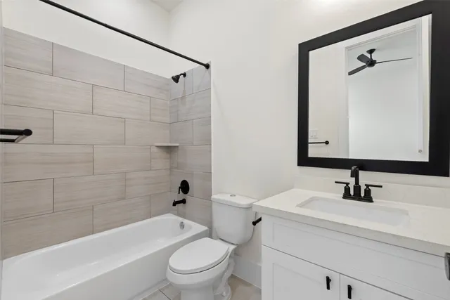 a bathroom with a bathtub shower sink vanity mirror and toilet