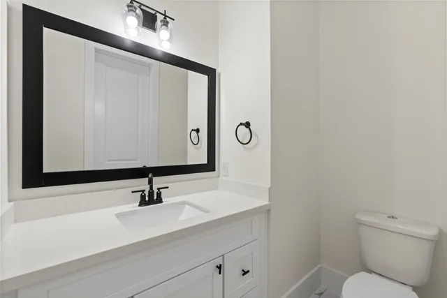 a bathroom with a sink a toilet and mirror