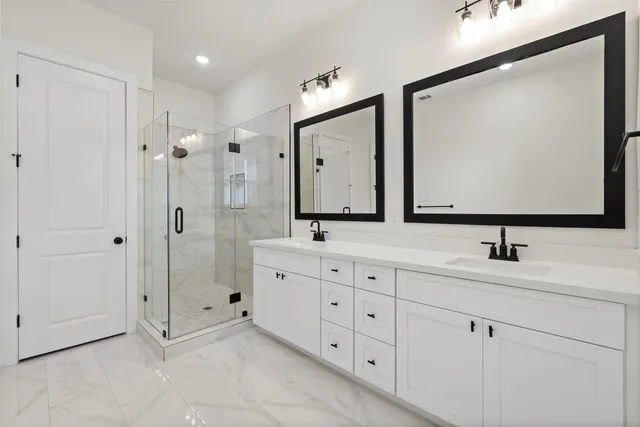 a bathroom with double sink and three mirror