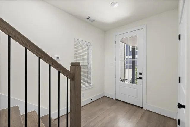 a view of an entryway with wooden floor and stairs