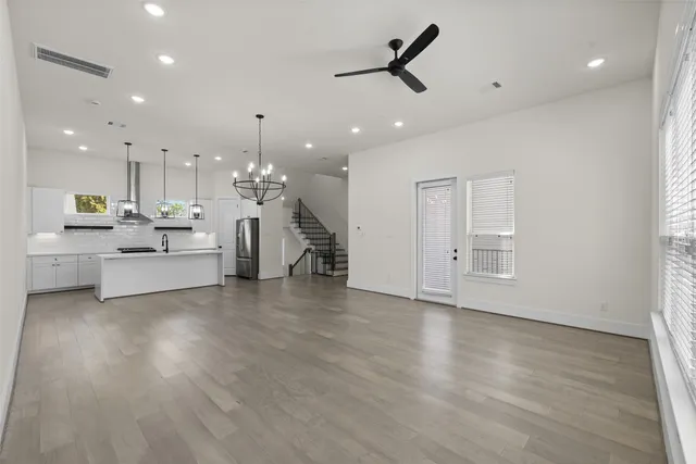 a view of a kitchen with kitchen island a sink stainless steel appliances and a window
