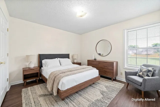 a bedroom with a bed a couch and a window