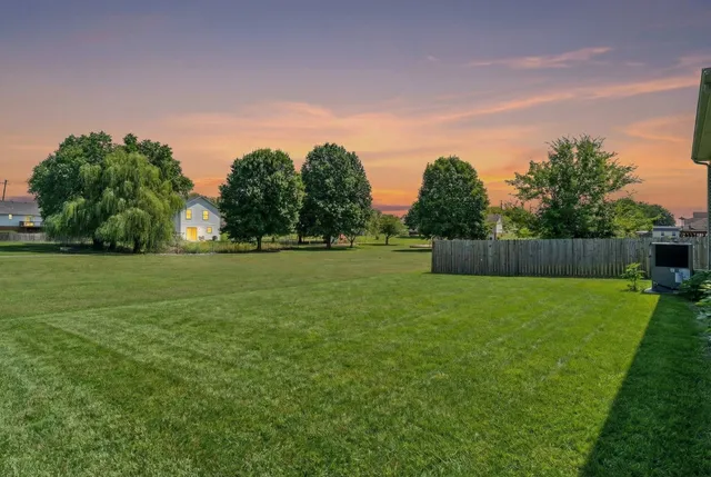 a backyard of a house with lots of green space and trees