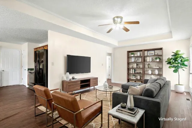 a living room with furniture a flat screen tv and a window