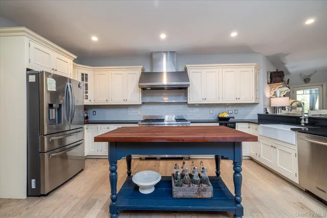 a view of a kitchen with a sink and dishwasher a stove top oven with wooden floor
